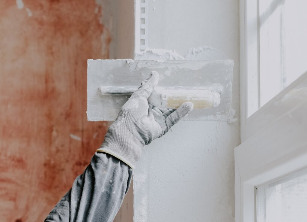 one-hand-in-a-construction-glove-a-plasterer-appli-2026-03-24-08-38-53-utc